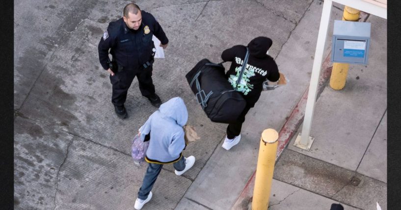 A Customs and Border Protection offer supervises as deportees arrive to cross back into Mexico on Wednesday in Nogales, Arizona. President Donald Trump signed executive orders on his first day in office declaring a state of emergency at the U.S. southern border, halting asylum claims and launching a campaign of mass deportations.