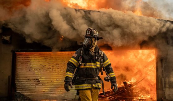 A firefighter works to put out a fire at the Altadena Golf Course in Altadena, California, on Thursday.