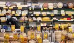 A supermarket employee wearing a mask poses in the cheese aisle at Fairway supermarket amid the coronavirus pandemic on May 1, 2020 in New York City, United States.