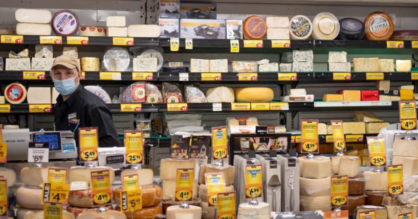 A supermarket employee wearing a mask poses in the cheese aisle at Fairway supermarket amid the coronavirus pandemic on May 1, 2020 in New York City, United States.