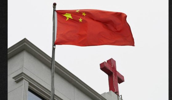 A photo taken on Jan. 15, 2024, shows a Chinese flag fluttering below a cross on a Christian church in Pingtan, in China's southeast Fujian province. Despite decades of oppression, the Christian population in China is estimated to exceed 350 million -- a number comparable to the population of the United States.