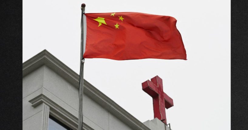 A photo taken on Jan. 15, 2024, shows a Chinese flag fluttering below a cross on a Christian church in Pingtan, in China's southeast Fujian province. Despite decades of oppression, the Christian population in China is estimated to exceed 350 million -- a number comparable to the population of the United States.