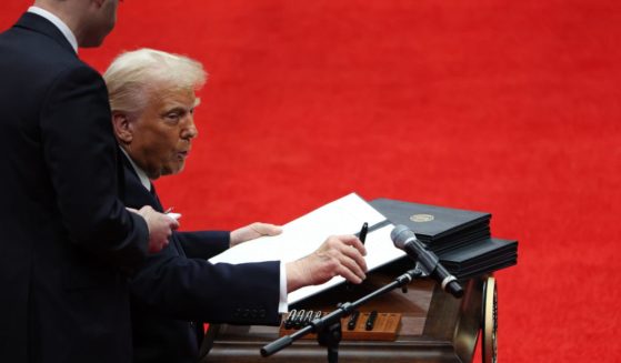 President Donald Trump signs executive orders during an indoor inauguration parade at Capital One Arena in Washington, D.C., on Monday.