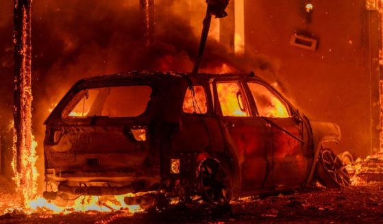 A car and house burn in the Eaton Fire in Altadena, California, on Wednesday.