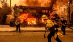 Firefighters work the scene as an apartment building burns during the Eaton fire in the Altadena area of Los Angeles county, California on January 8, 2025.