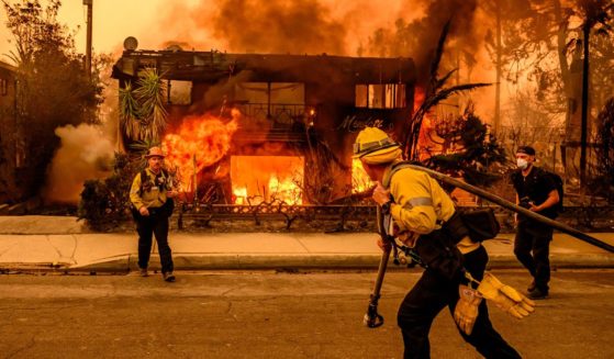 Firefighters work the scene as an apartment building burns during the Eaton fire in the Altadena area of Los Angeles county, California on January 8, 2025.