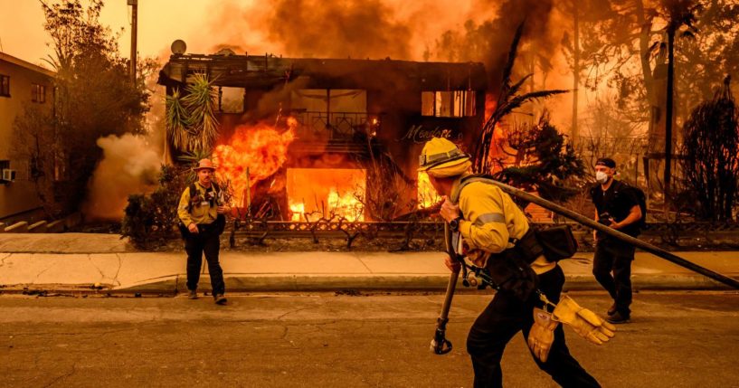 Firefighters work the scene as an apartment building burns during the Eaton fire in the Altadena area of Los Angeles county, California on January 8, 2025.