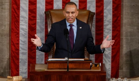 Rep. Hakeem Jeffries peaks on the first day of the 119th Congress in the House Chamber of the U.S. Capitol Building in Washington, D.C., on Friday.