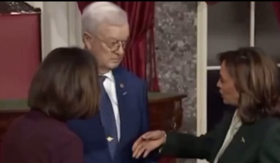 Vice President Kamala Harris, right, attempted to shake hands, apparently not noticing that Bruce Fischer held a cane in his right hand.