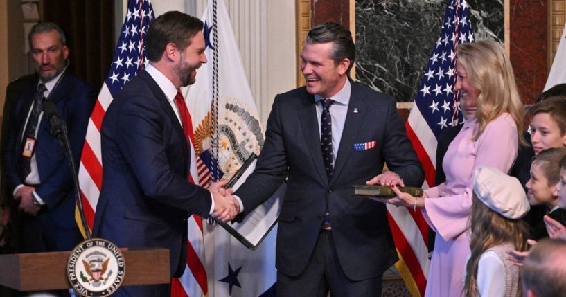 Defense Secretary Pete Hegseth shakes hands with Vice President J.D. Vance as he is surrounded by his wife Jennifer and his seven children after being sworn in as the new Secretary of Defense at the Eisenhower Executive Office Building at the White House in Washington, D.C., on January 25, 2025.