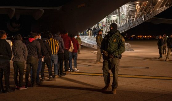 U.S. Customs and Border Protection Agents guide illegal immigrants onboard a C-17 Globemaster III at the Tucson International Airport in Tucson, Arizona, on Thursday.