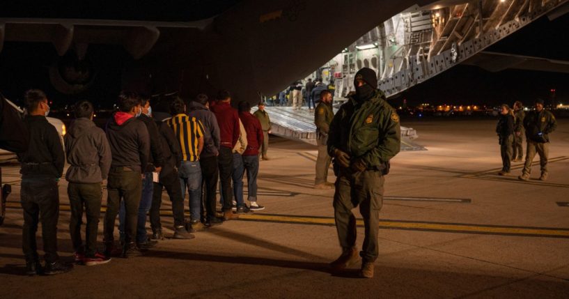 U.S. Customs and Border Protection Agents guide illegal immigrants onboard a C-17 Globemaster III at the Tucson International Airport in Tucson, Arizona, on Thursday.