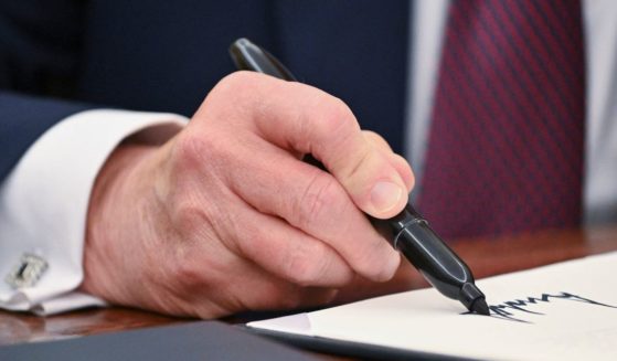 President Donald Trump signs an executive order in the Oval Office of the White House in Washington, D.C., on Thursday. (Roberto Schmidt -