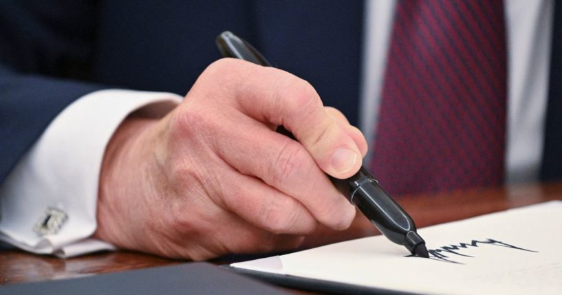 President Donald Trump signs an executive order in the Oval Office of the White House in Washington, D.C., on Thursday. (Roberto Schmidt -