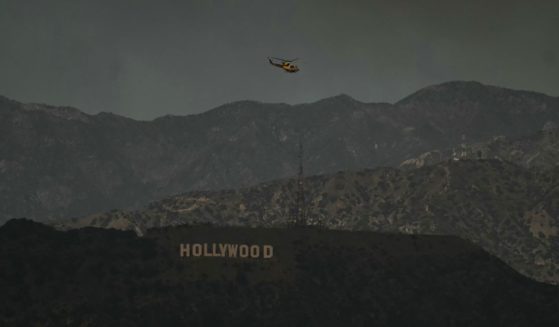 A firefighting helicopter flies above the Hollywood sign in Los Angeles, California, on Wednesday.