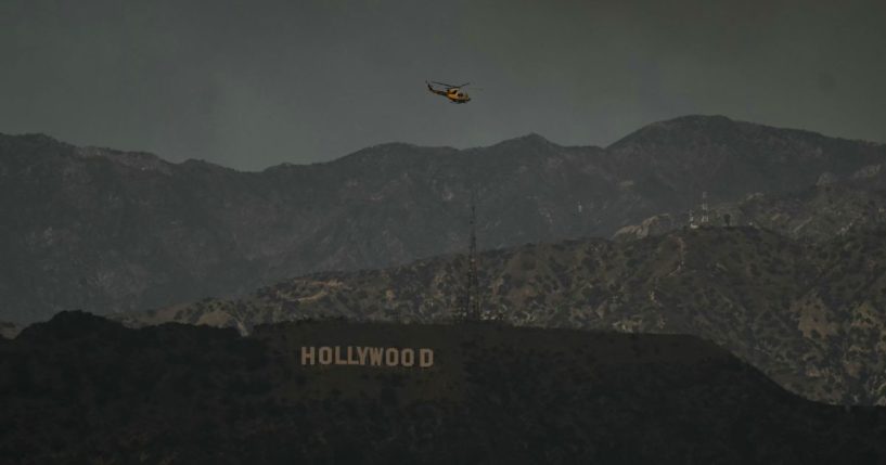 A firefighting helicopter flies above the Hollywood sign in Los Angeles, California, on Wednesday.