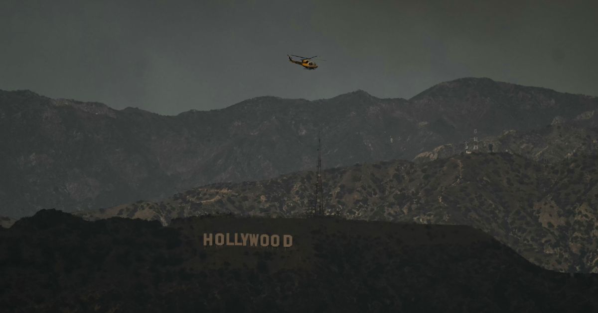 A firefighting helicopter flies above the Hollywood sign in Los Angeles, California, on Wednesday.