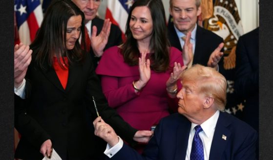 President Donald Trump hands a pen to Allyson Phillips, mother of Laken Riley, after signing the Laken Riley Act in the East Room of the White House, Wednesday in Washington.