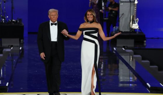 President Donald Trump, left, and first lady Melania Trump, right, arrive to dance at the Liberty Ball in Washington, D.C., on Monday.