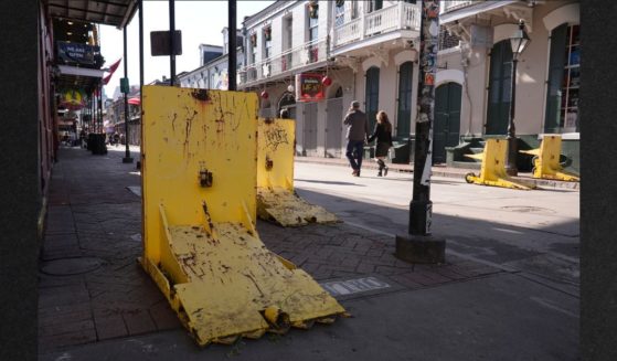 Tourists walk past temporary barriers on Bourbon Street, Thursday in New Orleans. The city said it was in the process of replacing its system of bollards, or security barriers, when a terrorist drove around a police car and rammed into a crowd of New Year's revelers.