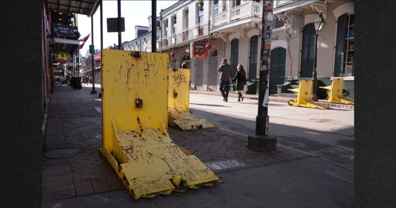 Tourists walk past temporary barriers on Bourbon Street, Thursday in New Orleans. The city said it was in the process of replacing its system of bollards, or security barriers, when a terrorist drove around a police car and rammed into a crowd of New Year's revelers.