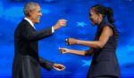 Former President Barack Obama, left, greets former first lady Michelle Obama as he arrives to speak on stage during the Democratic National Convention in a photo dated Aug. 20, 2024.