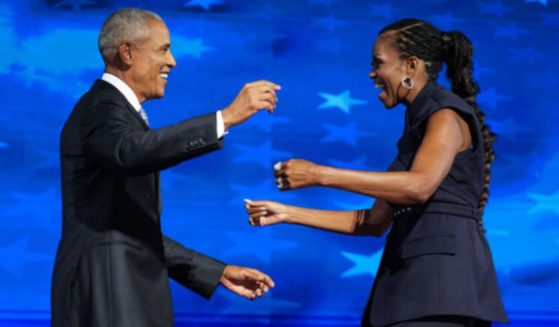 Former President Barack Obama, left, greets former first lady Michelle Obama as he arrives to speak on stage during the Democratic National Convention in a photo dated Aug. 20, 2024.