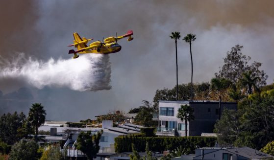 A Super SCooper plane drops water on the Palisades fire on Tuesday, Jan. 7, 2025 in Pacific Palisades, CA.