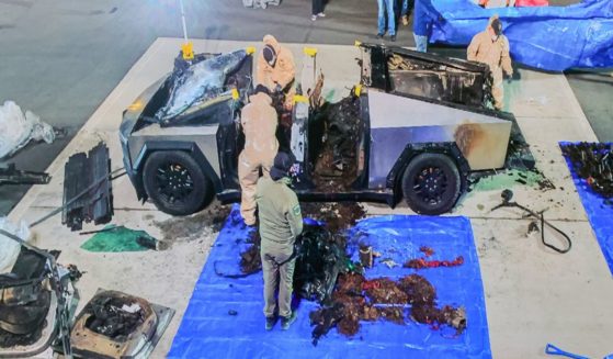 A monitor displays an image of authorities investigating a Tesla Cybertruck that exploded on New Year's Day in front of the entrance to the Trump International Hotel & Tower Las Vegas during a news conference at Las Vegas Metropolitan Police Department headquarters on January 02, 2025 in Las Vegas, Nevada.