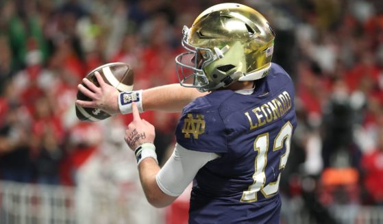 Notre Dame quarterback Riley Leonard celebrates a first quarter touchdown against the Ohio State Buckeyes during the 2025 CFP National Championship in Atlanta, Georgia, on Monday by pointing to a Bible verse on his wrist.