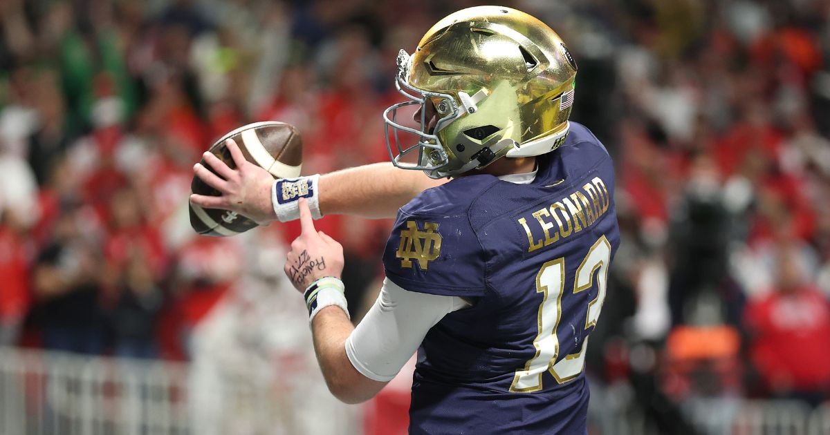 Notre Dame quarterback Riley Leonard celebrates a first quarter touchdown against the Ohio State Buckeyes during the 2025 CFP National Championship in Atlanta, Georgia, on Monday by pointing to a Bible verse on his wrist.