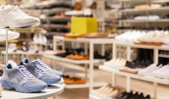 This stock image shows a variety of shoes in a window display.