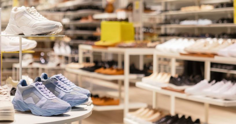 This stock image shows a variety of shoes in a window display.