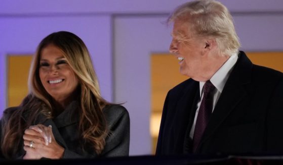 Former and future first lady Melania Trump, left, and President-elect Donald Trump, right, watch a firework display from the Trump National Golf Club in Sterling, Virginia, on Saturday.