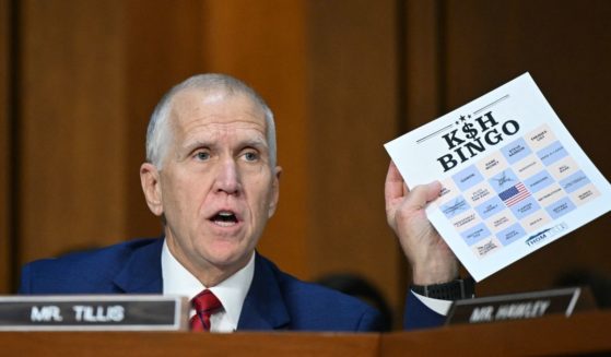 Sen. Thom Tillis holds up a "Kash Bingo" card as Kash Patel testifies during a Senate Judiciary Committee hearing on his nomination to be FBI Director, on Capitol Hill in Washington, D.C., on Thursday. (Mandel Ngan - AFP / Gett