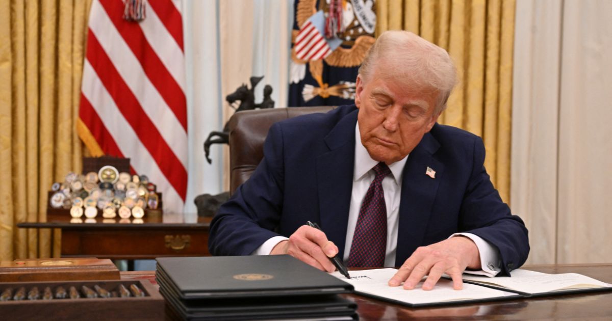 President Donald Trump signs an executive order in the Oval Office of the White House in Washington, D.C., on January 23, 2025.