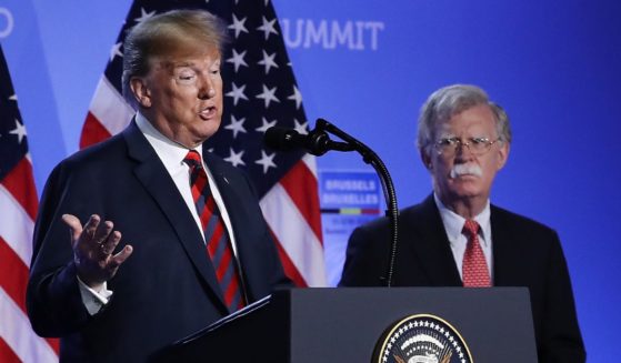 Donald Trump, serving as the 45th president, is flanked by then-National Security Advisor John Bolton at a news conference on the second day of the 2018 NATO Summit in Brussels, Belgium, on July 12, 2018.