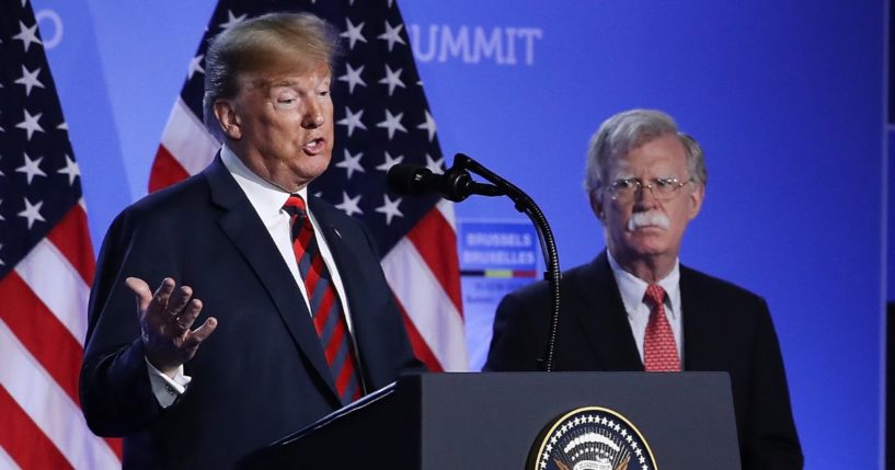 Donald Trump, serving as the 45th president, is flanked by then-National Security Advisor John Bolton at a news conference on the second day of the 2018 NATO Summit in Brussels, Belgium, on July 12, 2018.