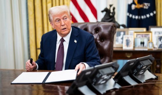 President Donald Trump speaks with reporters and signs executive orders in the Oval Office at the White House on in Washington, D.C.