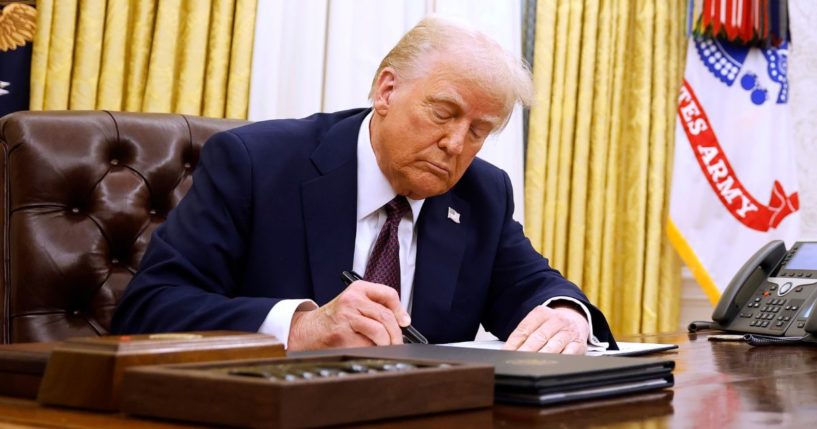 President Donald Trump signs a series of executive orders in the Oval Office of the White House.