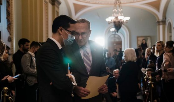 Senate Majority Leader Chuck Schumer (D-NY) confers with staffer Alex Nguyen during a news conference after a weekly Senate Democratic policy luncheon at the U.S. Capitol on Capitol Hill on Tuesday, March 8, 2022 in Washington, DC.