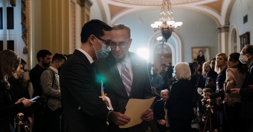 Senate Majority Leader Chuck Schumer (D-NY) confers with staffer Alex Nguyen during a news conference after a weekly Senate Democratic policy luncheon at the U.S. Capitol on Capitol Hill on Tuesday, March 8, 2022 in Washington, DC.