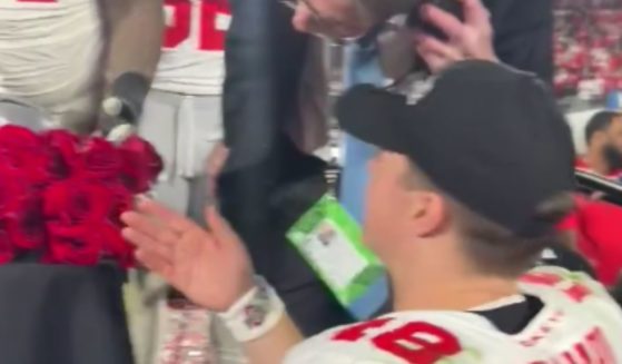 Ohio State Buckeyes quarterback Will Howard speaks to an event worker following the Rose Bowl after he was kept from celebrating with his teammates on stage.