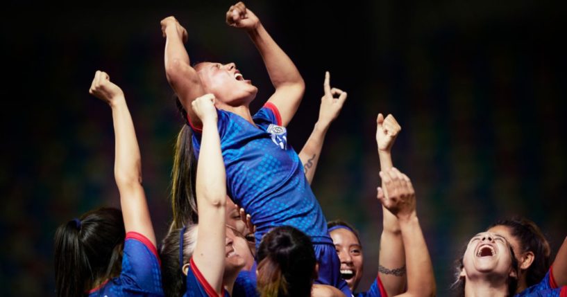 This stock image shows a women's soccer team celebrating a win.