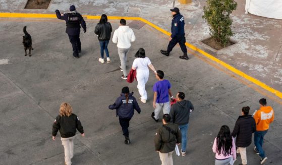 In this aerial view, Mexican immigration officials and police escort deportees after they were sent back into Mexico on January 22, 2025 as seen from Nogales, Arizona.