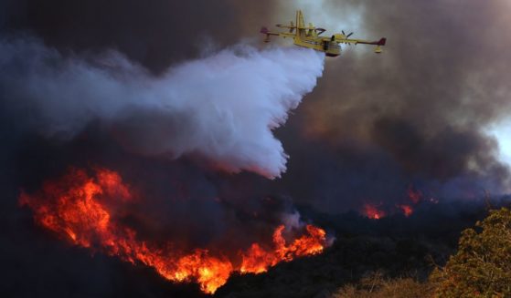 A firefighting plane makes a drop on the Palisades fire in Pacific Palisades on Tuesday, Jan. 7, 2024.