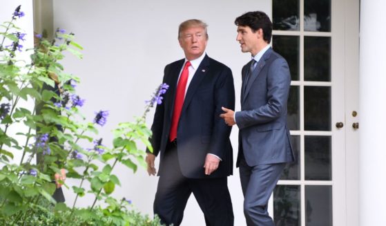 US President Donald Trump (L) listens to Canadian Prime Minister Justin Trudeau as they walk towards the Oval Office of the White House in Washington, DC, on October 11, 2017.