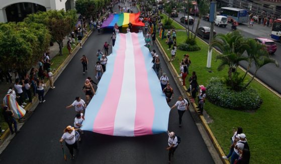 People carry Transgender and Gay Pride flags at a demonstration as part of the LGBTQIA+ pride parade on June 24, 2023 in San Salvador, El Salvador.