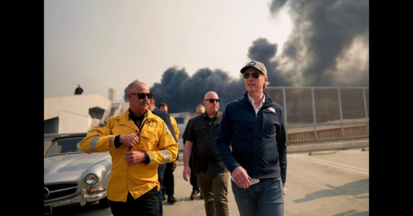 California Governor Gavin Newsom (R) tours the downtown business district of Pacific Palisades as the Palisades Fire continues to burn on January 8, 2025 in Los Angeles, California.