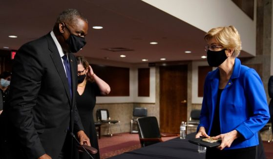 Elizabeth Warren (D-MA) (R) speaks to U.S. Secretary of Defense Lloyd Austin during a break in the Senate Armed Services Committee hearing on the conclusion of military operations in Afghanistan and plans for future counterterrorism operations on Capitol Hill on September 28, 2021 in Washington, DC.